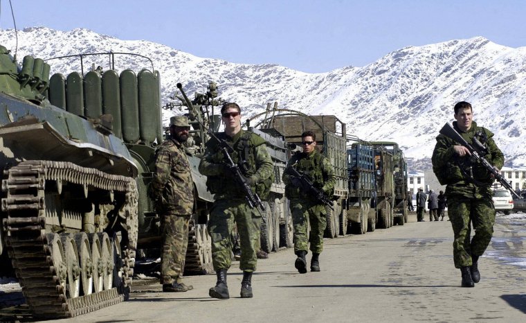 KABOUL, AFGHANISTAN : Des soldats canadiens de la Force internationale d'assistance à la sécurité (FIAS) dirigée par l'OTAN patrouillent près de véhicules blindés alignés à Kaboul, le 10 février 2004. Les véhicules et certaines armes lourdes, dont des chars, des pièces d'artillerie et des véhicules blindés de transport de troupes, ont été récupérés auprès des milices afghanes, pour la plupart fidèles au ministre afghan de la défense, Mohammad Qasim Fasim, dans le cadre d'un programme de désarmement en cours sous la direction du ministère afghan de la défense. AFP PHOTO/Shah Marai (Le crédit photo doit se lire SHAH MARAI/AFP via Getty Images)