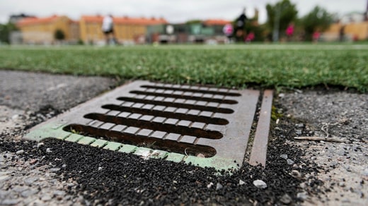 Granulés de caoutchouc microplastiques dans un puits d'eau pluviale sur un terrain de gazon artificiel. L'environnement est la principale raison de l'interdiction à venir.