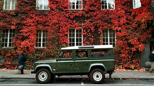 Un Land Rover Defender 110 CSW devant un fond fleuri.