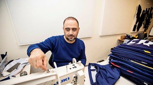 Emad Alkasem a travaillé comme tailleur et vendeur à Damas. Aujourd'hui, il aide à coudre des sacs de sport pour 800 jeunes à Göteborg.