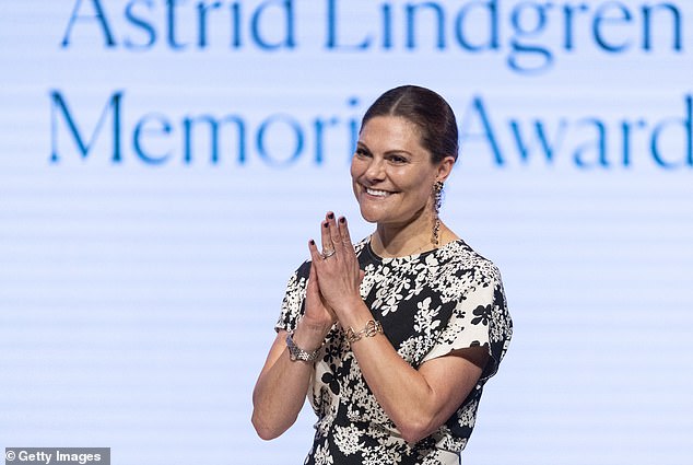 La princesse a associé sa robe longue printanière à des talons aiguilles noirs, une montre argentée, des bracelets et des boucles d'oreilles métalliques et florales.
