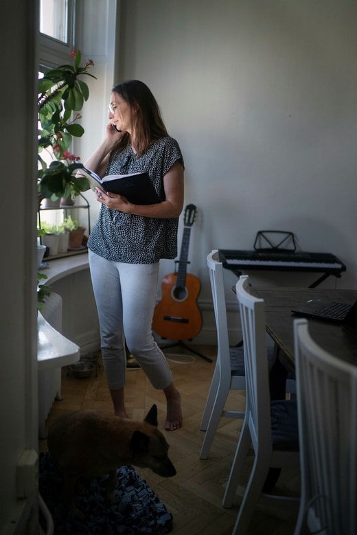 Une partie du travail d'un conseiller en endettement consiste à appeler les sociétés de recouvrement et à négocier les taux d'intérêt pour ses clients. Sur le sol, le chien Sasha lui tient compagnie.