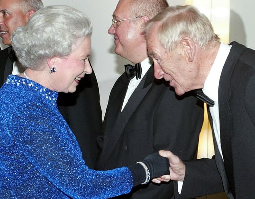 Bert Trautmann salue la reine Élisabeth II en 2004, quelques jours après avoir reçu l'Ordre de l'Empire britannique (OBE).