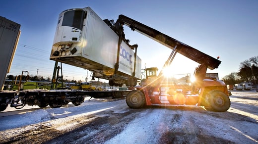 Les conteneurs sont rechargés entre le train et le wagon.