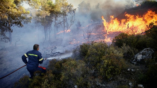Un pompier grec tente d'éteindre le feu à Asklipio, Rhodes.
