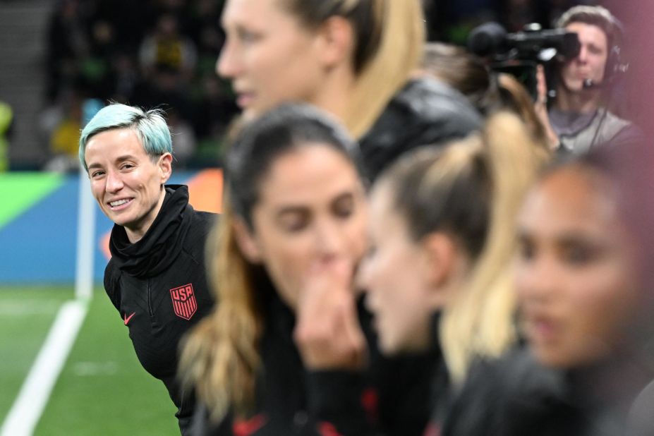 Rapinoe, à gauche, regarde depuis le banc des remplaçantes. 