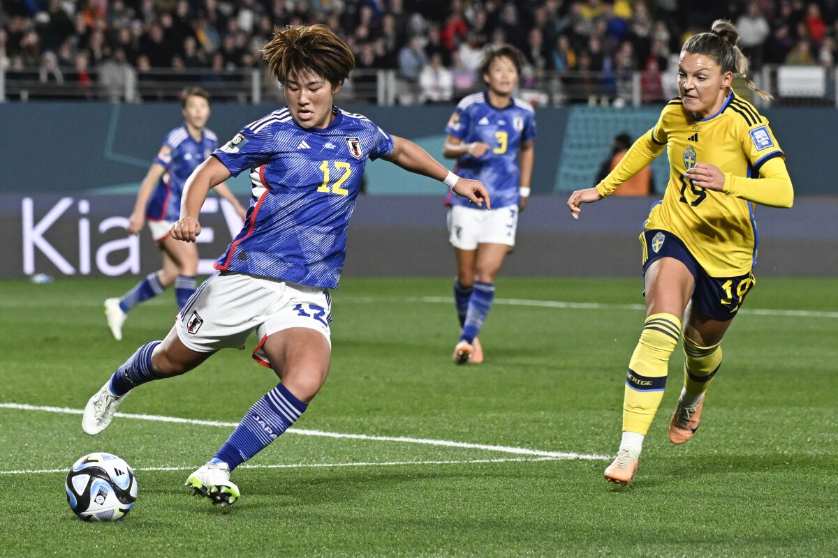 Hana Takahashi du Japon frappe le ballon pour éviter que Johanna Kaneryd de la Suède ne l'emporte lors d'un match de quart de finale de la Coupe du monde. 