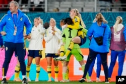 La Suédoise Elin Rubensson saute dans les bras de la gardienne Zecira Musovic en célébrant la fin du quart de finale de la Coupe du monde féminine de football entre le Japon et la Suède à Eden Park à Auckland, Nouvelle-Zélande, vendredi 11 août 2023.