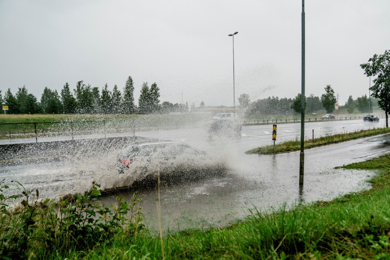 Une voiture roule dans les eaux de crue sur une sortie de l'autoroute E6 à Klofta au nord d'Oslo, Norvège.