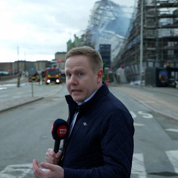 Un homme se tient devant la bourse détruite à Copenhague.